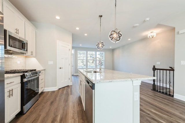 kitchen featuring appliances with stainless steel finishes, white cabinetry, sink, and a kitchen island with sink