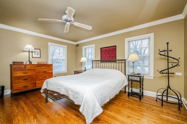 bedroom with crown molding, hardwood / wood-style flooring, and ceiling fan