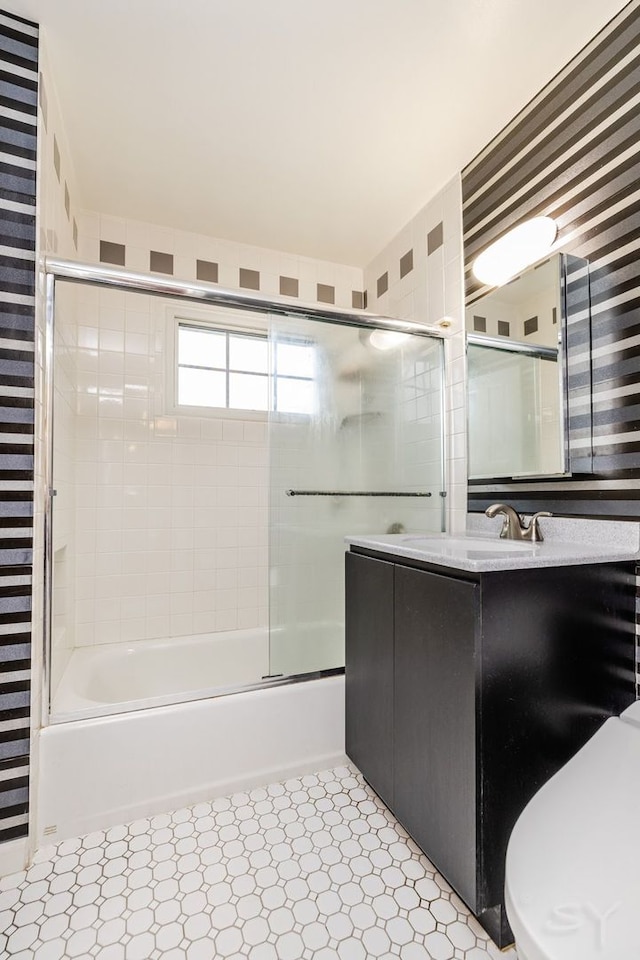 full bathroom featuring toilet, vanity, and shower / bath combination with glass door