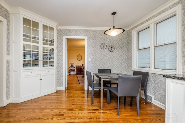 dining room featuring crown molding and light hardwood / wood-style flooring