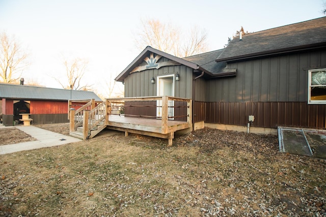 view of side of home with a deck and a lawn