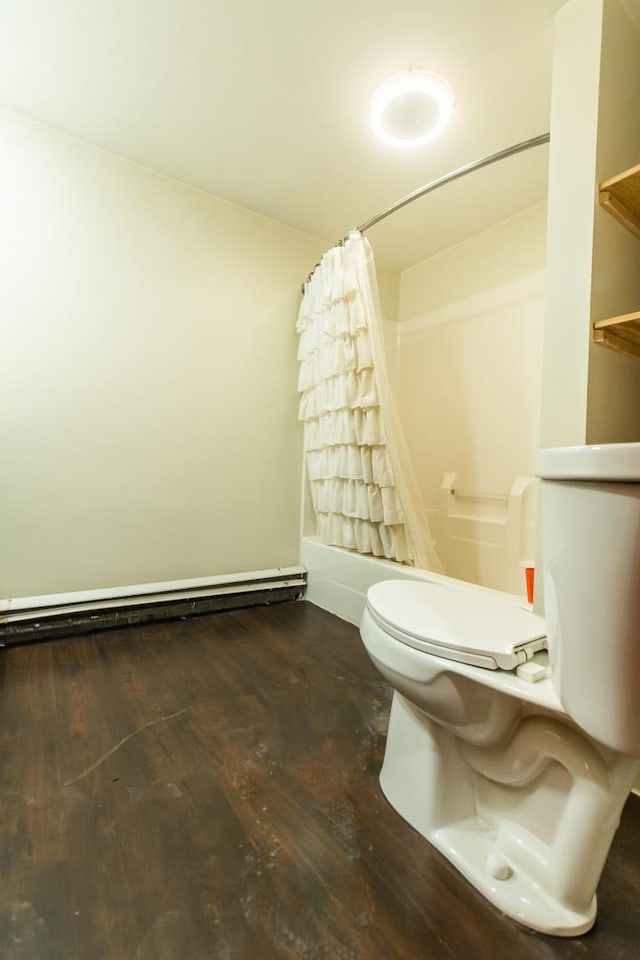 bathroom featuring toilet, hardwood / wood-style flooring, a baseboard heating unit, and shower / bath combo with shower curtain