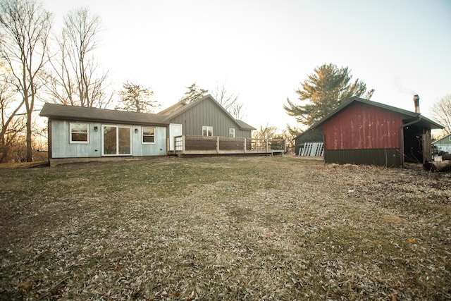 rear view of property featuring a wooden deck and a yard