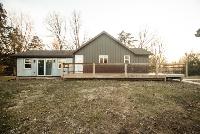 back of property with a lawn and a wooden deck