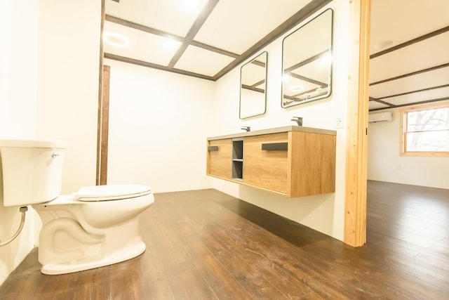 bathroom featuring toilet, hardwood / wood-style floors, and vanity