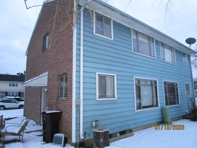 view of snowy exterior with central AC unit