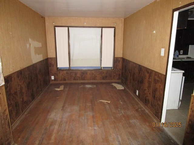 spare room featuring hardwood / wood-style flooring and wooden walls