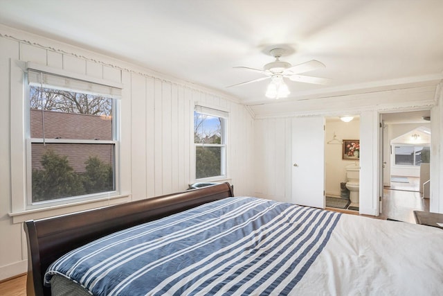 bedroom with ceiling fan, light wood-type flooring, and ensuite bathroom