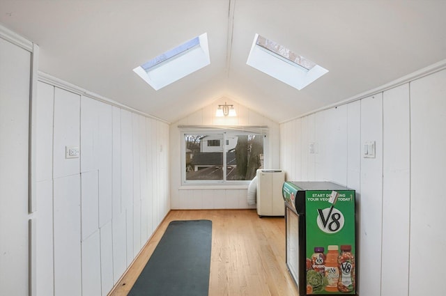 bonus room featuring light wood-type flooring, lofted ceiling, and wooden walls