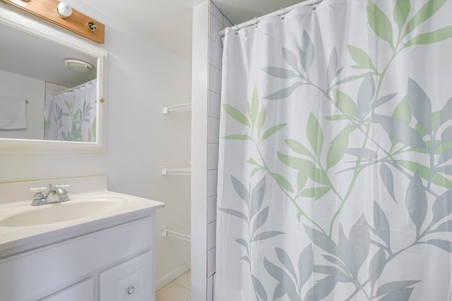 bathroom with walk in shower, vanity, and tile patterned flooring