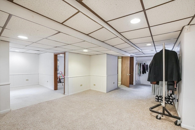 basement featuring light colored carpet and a drop ceiling