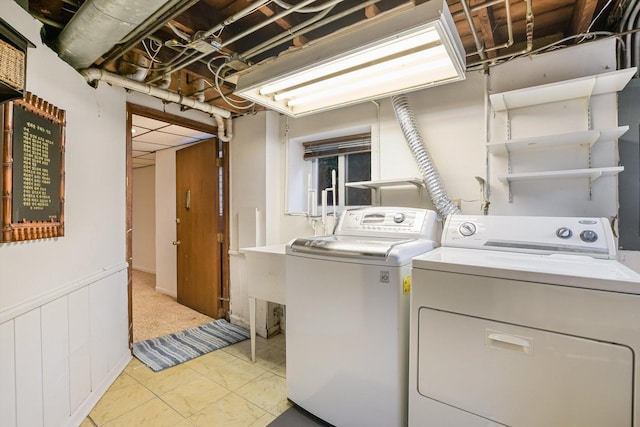 clothes washing area with washer and dryer and light tile patterned floors