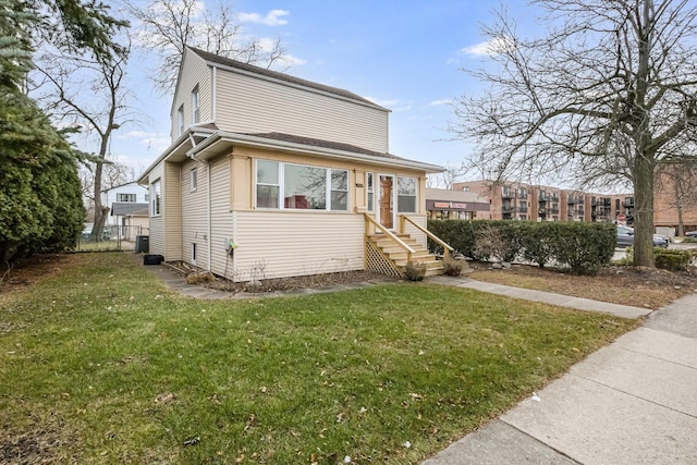 view of front of home with a front yard and central AC