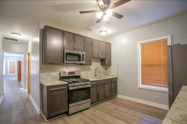 kitchen featuring backsplash, appliances with stainless steel finishes, sink, and dark brown cabinetry