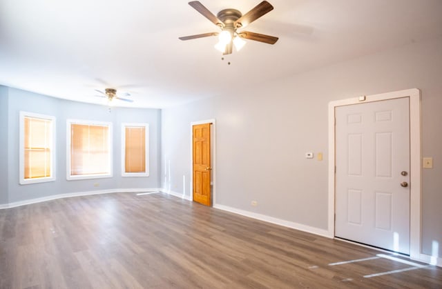 empty room with ceiling fan and dark hardwood / wood-style floors