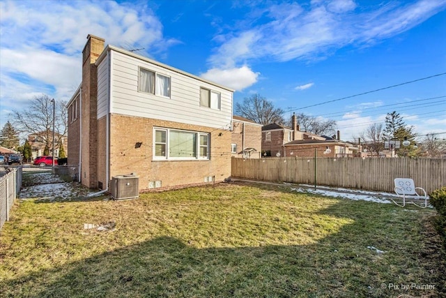 back of house featuring cooling unit and a yard