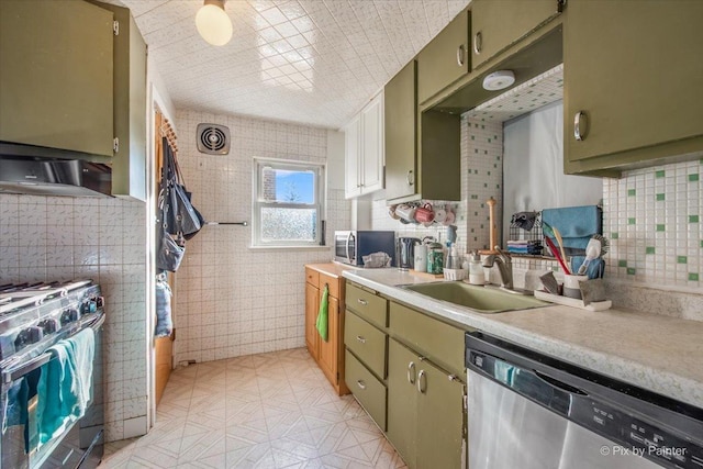 kitchen featuring sink, stainless steel appliances, green cabinets, and tile walls