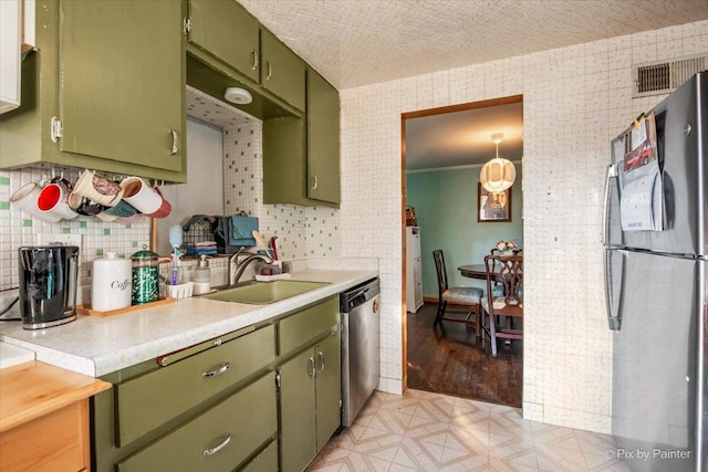 kitchen featuring sink, green cabinets, and appliances with stainless steel finishes