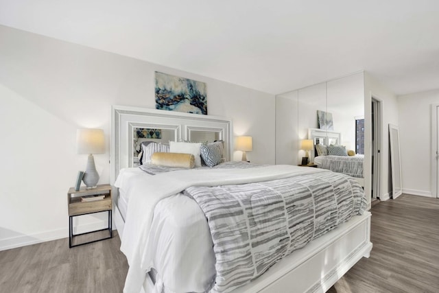 bedroom with baseboards and wood finished floors