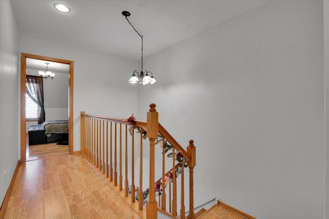 stairway with an inviting chandelier and hardwood / wood-style flooring