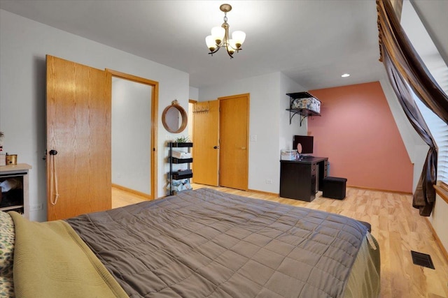 bedroom with light hardwood / wood-style floors and a chandelier