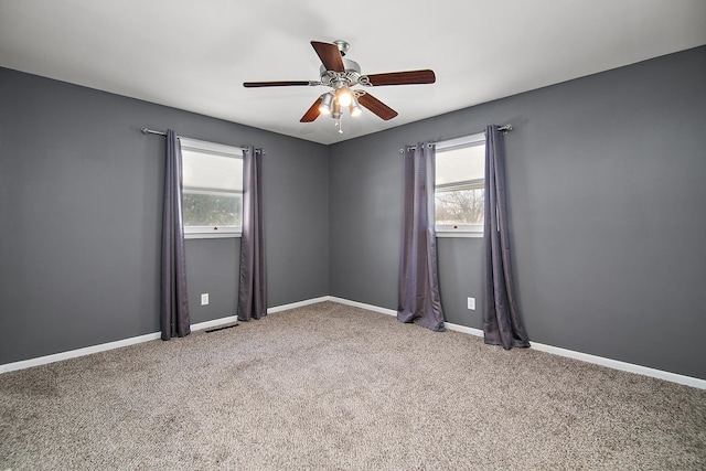 unfurnished room with ceiling fan and carpet