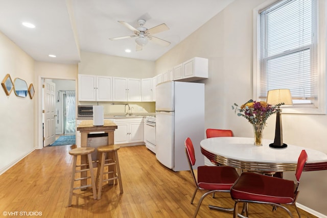 kitchen featuring range, white cabinets, white refrigerator, and light wood-type flooring