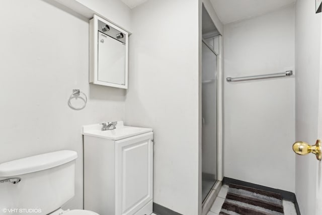 bathroom featuring toilet, vanity, and an enclosed shower