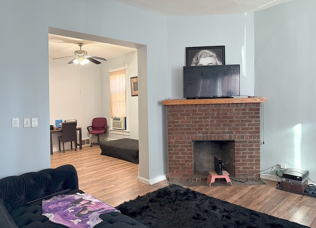 living room with a brick fireplace, hardwood / wood-style floors, ceiling fan, and cooling unit