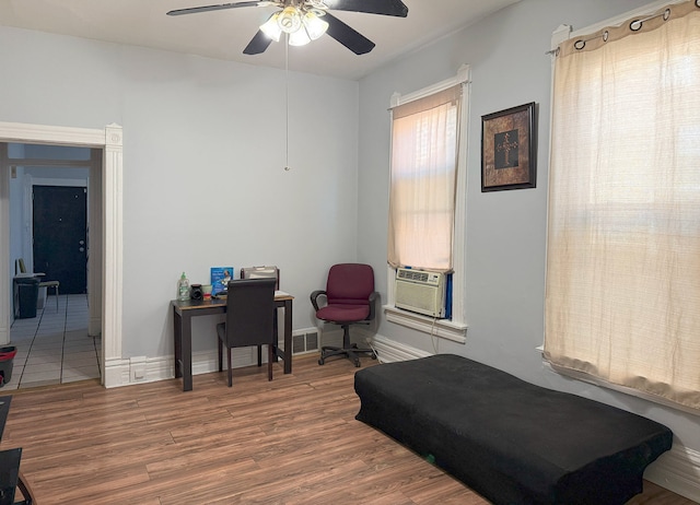 bedroom featuring hardwood / wood-style flooring, ceiling fan, and cooling unit