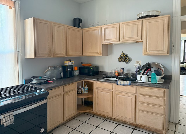 kitchen featuring gas range, sink, and light brown cabinetry