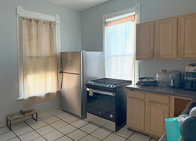 kitchen featuring stainless steel appliances, light tile patterned flooring, and light brown cabinets