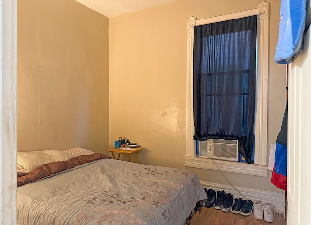 bedroom with cooling unit and wood-type flooring