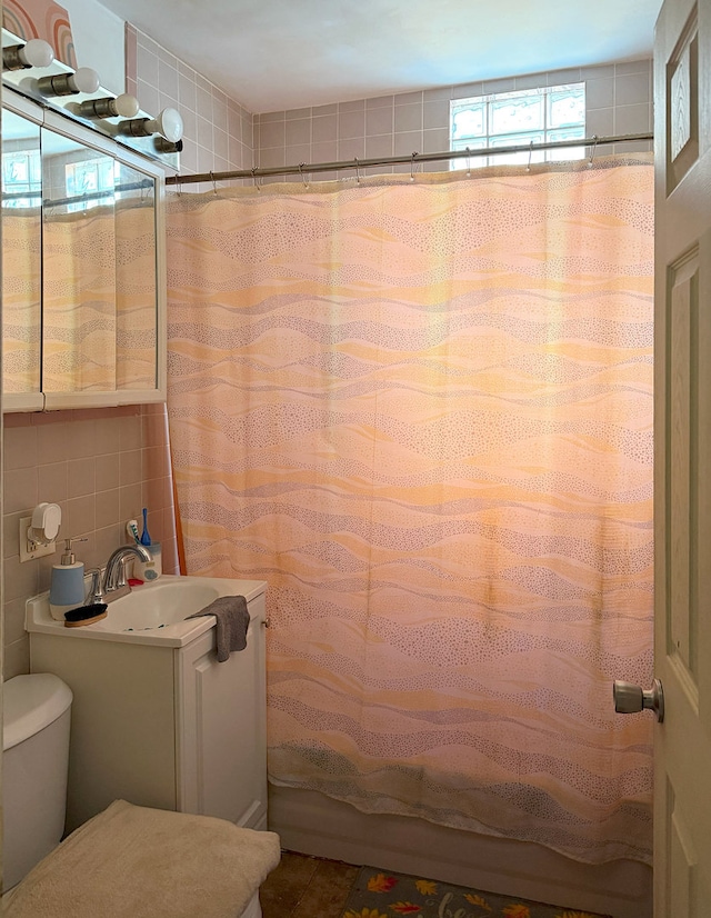 bathroom featuring tile walls, vanity, curtained shower, and toilet