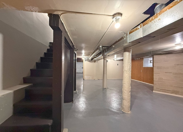 basement featuring wood walls