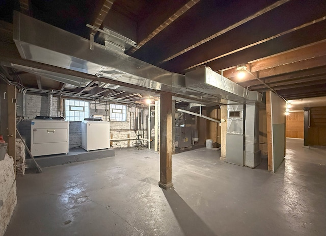 basement featuring heating unit and independent washer and dryer