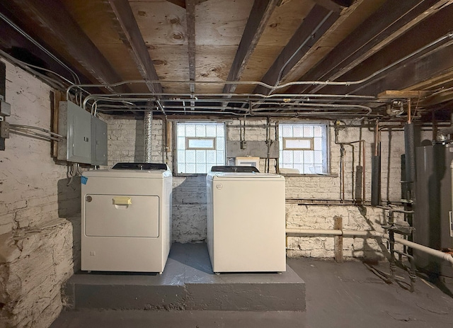 basement featuring electric panel, washing machine and dryer, and gas water heater