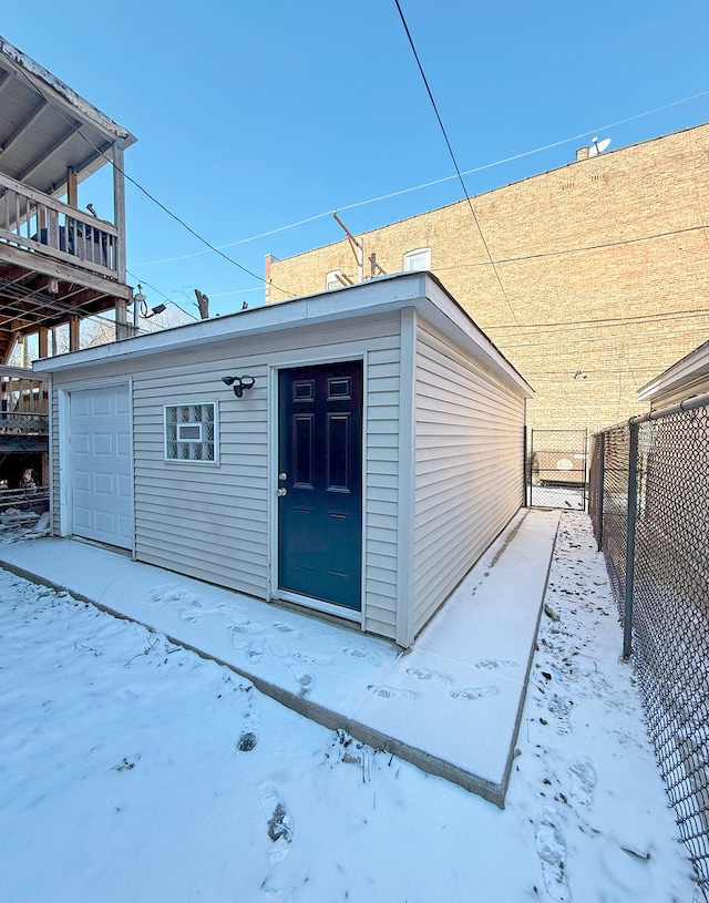 view of snow covered exterior with a garage and an outdoor structure