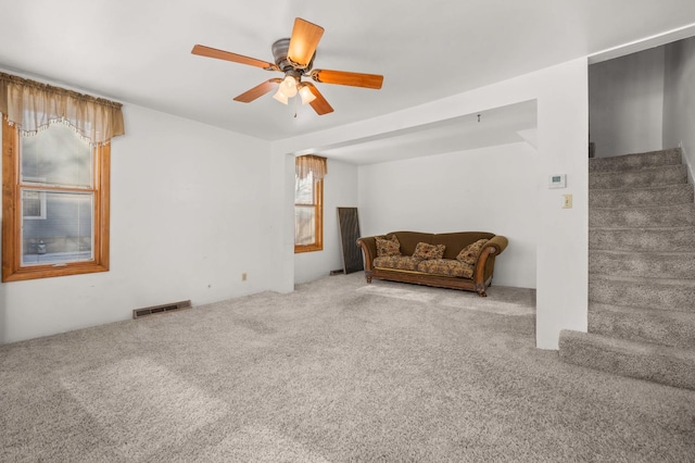 living area featuring carpet floors and ceiling fan