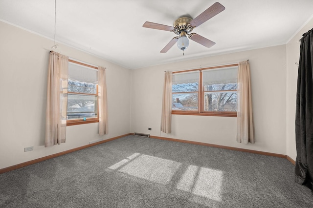 spare room featuring carpet floors, a healthy amount of sunlight, and ceiling fan