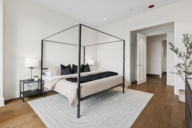 bedroom with recessed lighting, wood finished floors, visible vents, and baseboards