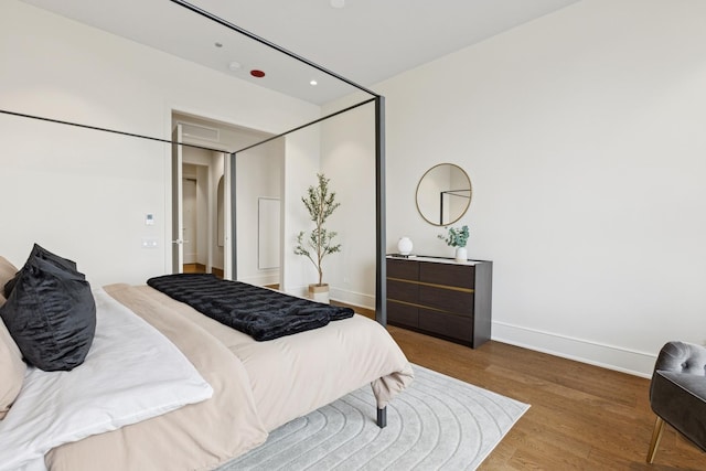 bedroom featuring visible vents, baseboards, wood finished floors, and recessed lighting