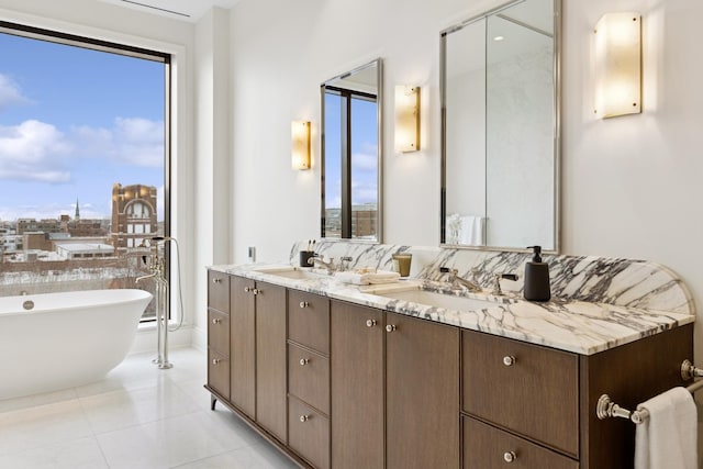 bathroom featuring double vanity, tile patterned flooring, a freestanding bath, and a sink