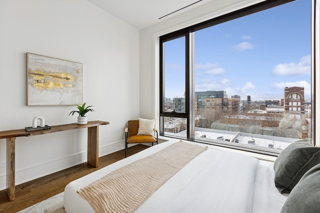 bedroom with a view of city, dark wood-style flooring, and baseboards