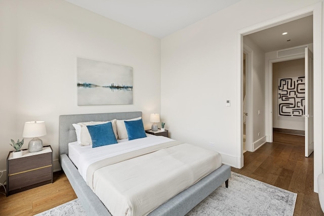 bedroom featuring wood finished floors, visible vents, and baseboards