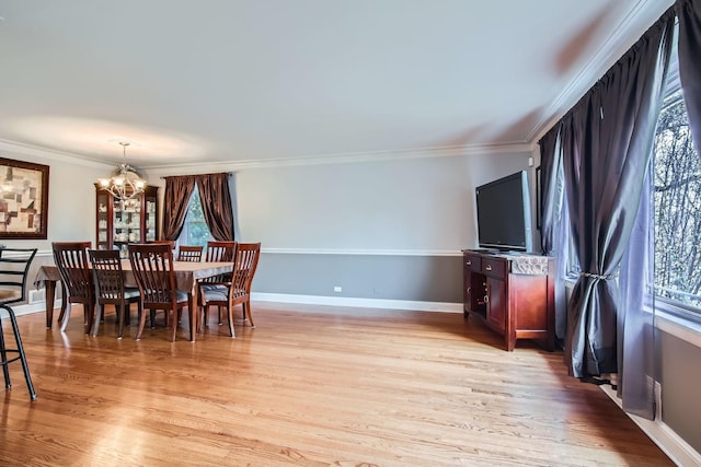 dining room featuring ornamental molding, a notable chandelier, and light wood-type flooring