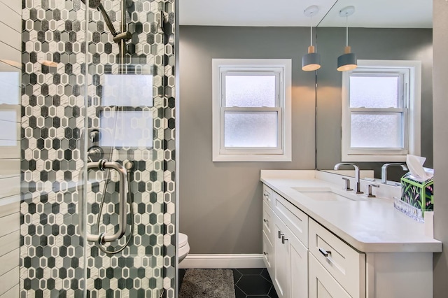 bathroom with a shower with shower door, vanity, tile patterned floors, and toilet