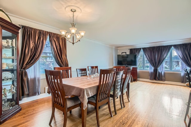 dining room featuring a notable chandelier, ornamental molding, and light hardwood / wood-style floors