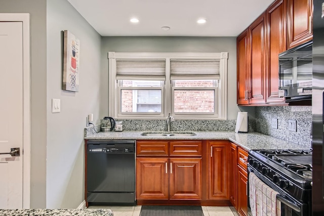 kitchen with tasteful backsplash, light tile patterned flooring, light stone countertops, black appliances, and sink