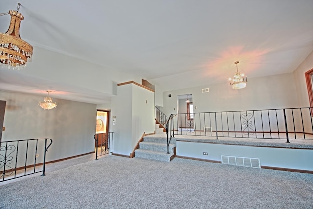 carpeted spare room with lofted ceiling and a chandelier